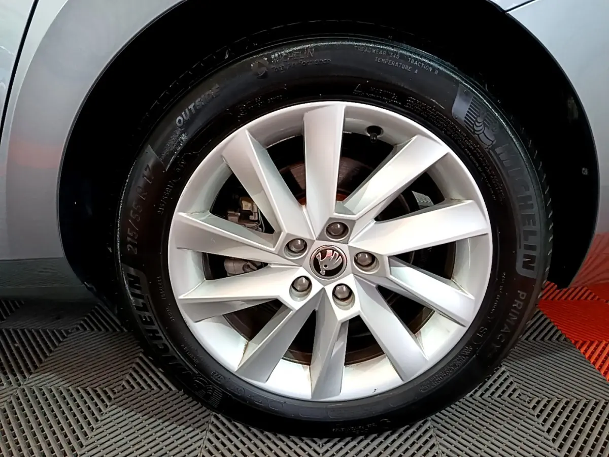 Gros plan sur la jante alliage argentée et pneu Michelin d'une Skoda Superb gris clair, côté droit.