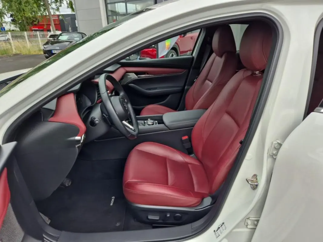 Intérieur de la Mazda3 2020 blanc, vue côté gauche, sièges et garnitures en cuir rouge exclusif.