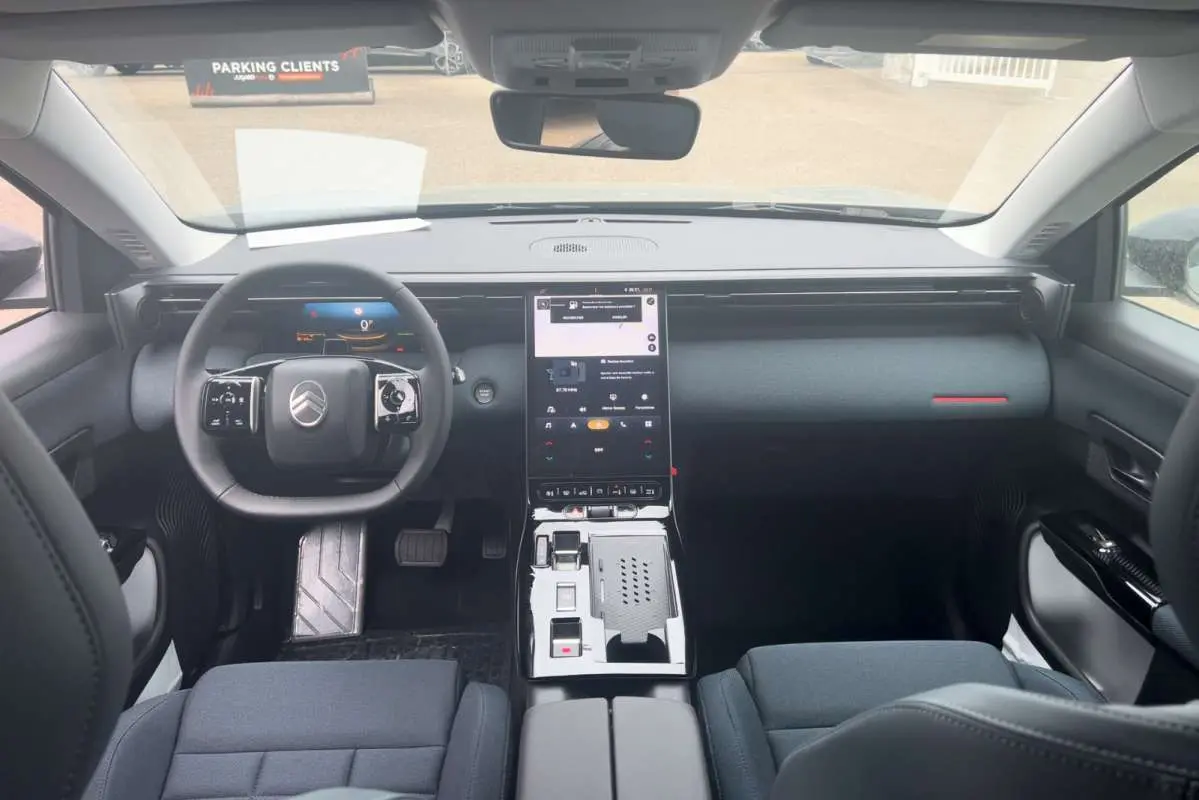 Vue intérieure avant du Citroën C5 Aircross Hybrid 2026, tableau de bord noir avec écran tactile vertical et volant cuir multifonctions.