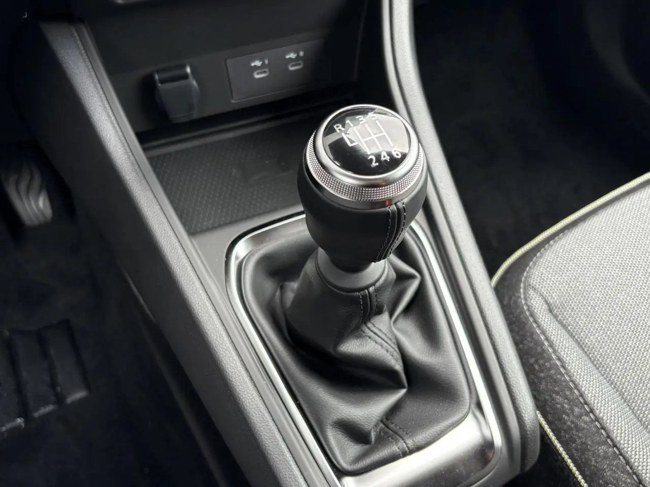 Le levier de vitesse manuel noir de la Renault Captur 2025 avec coutures visibles et console centrale grise.