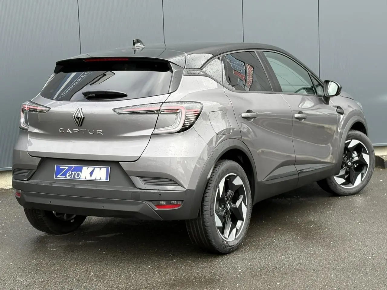 Vue 3/4 arrière droite d'un Renault Captur gris Cassiopée avec toit noir étoilé et jantes aluminium 18 pouces.