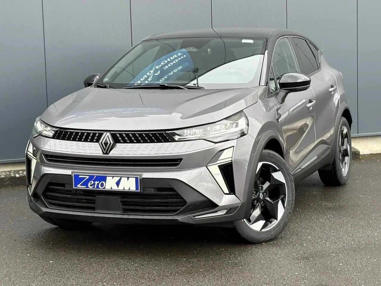 Renault Captur 2025 gris Cassiopée vu de face droite, avec calandre moderne et jantes aluminium noires.