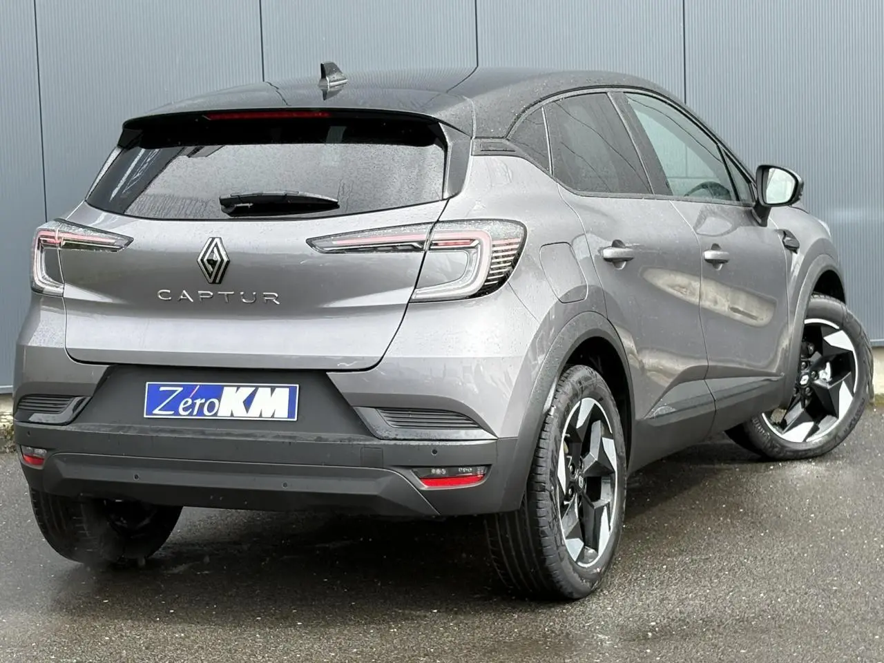 Vue 3/4 arrière droite du Renault Captur gris Cassiopée avec jantes noires et toit noir étoilé.