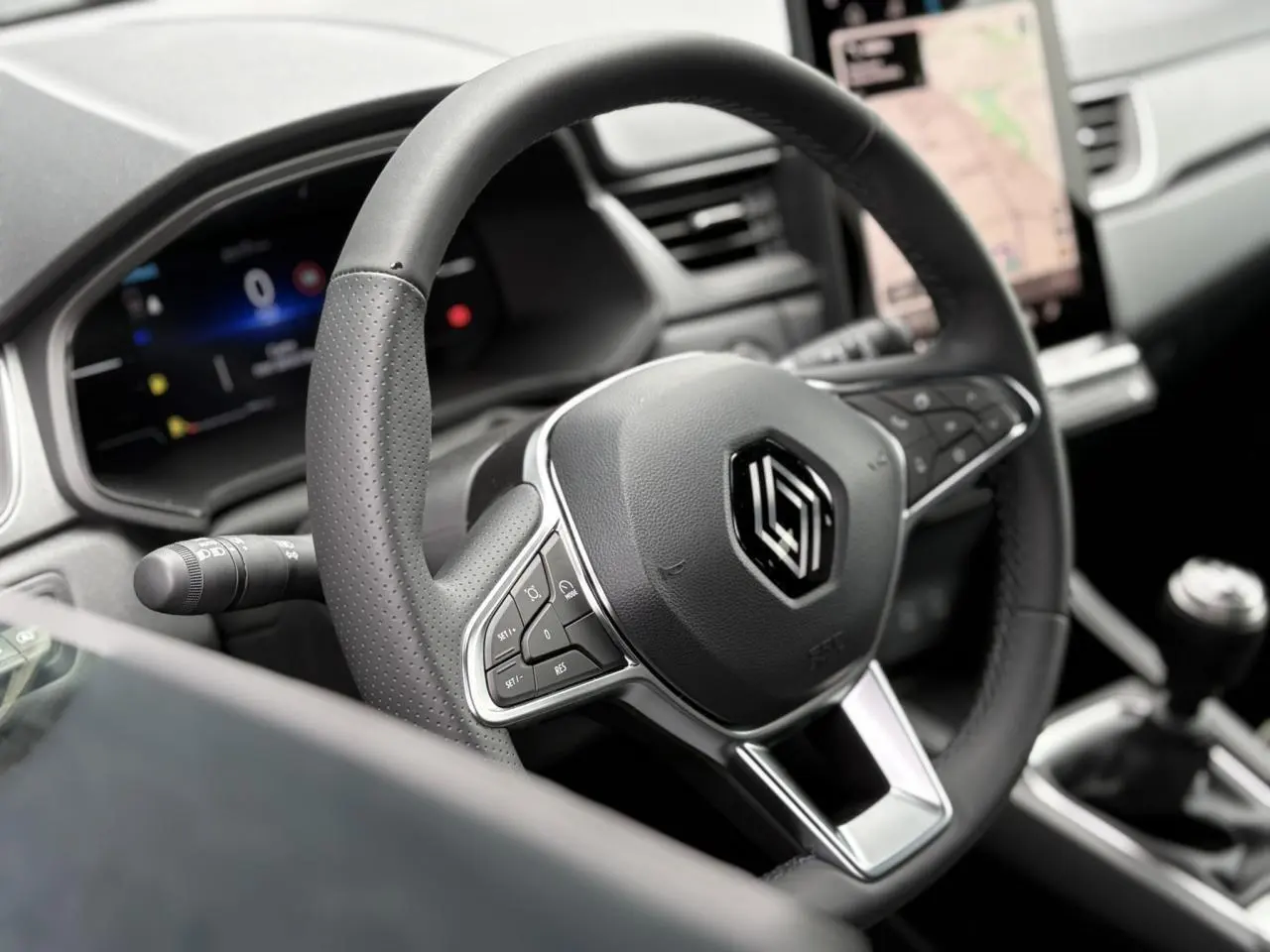 Volant en cuir noir de Renault Captur 2025 avec commandes intégrées et levier de vitesses manuel visible en arrière-plan