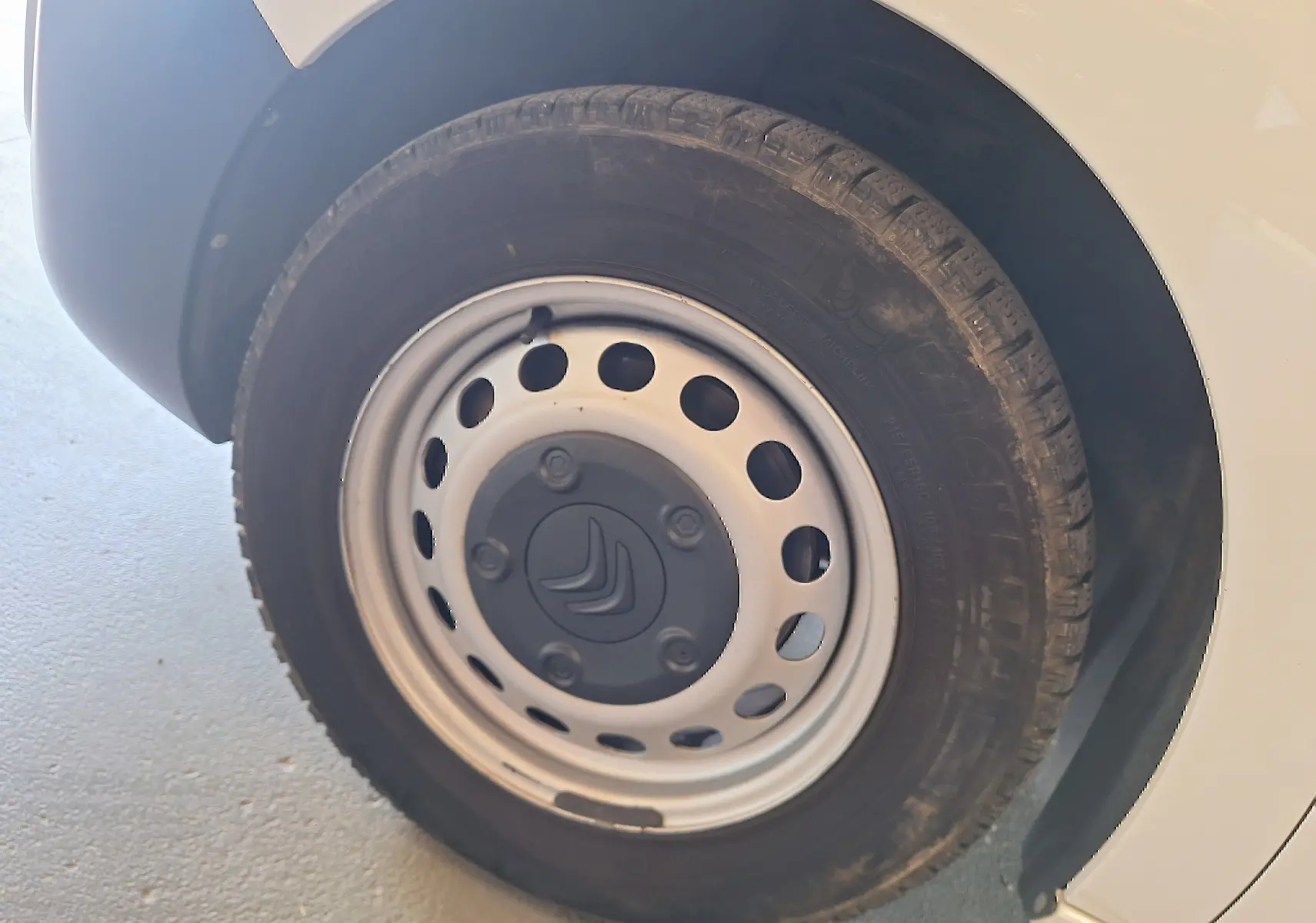 Gros plan sur la roue avant droite blanche d'un Citroën Jumpy 2.0 BlueHDi 120 Club avec jante acier et logo Citroën.