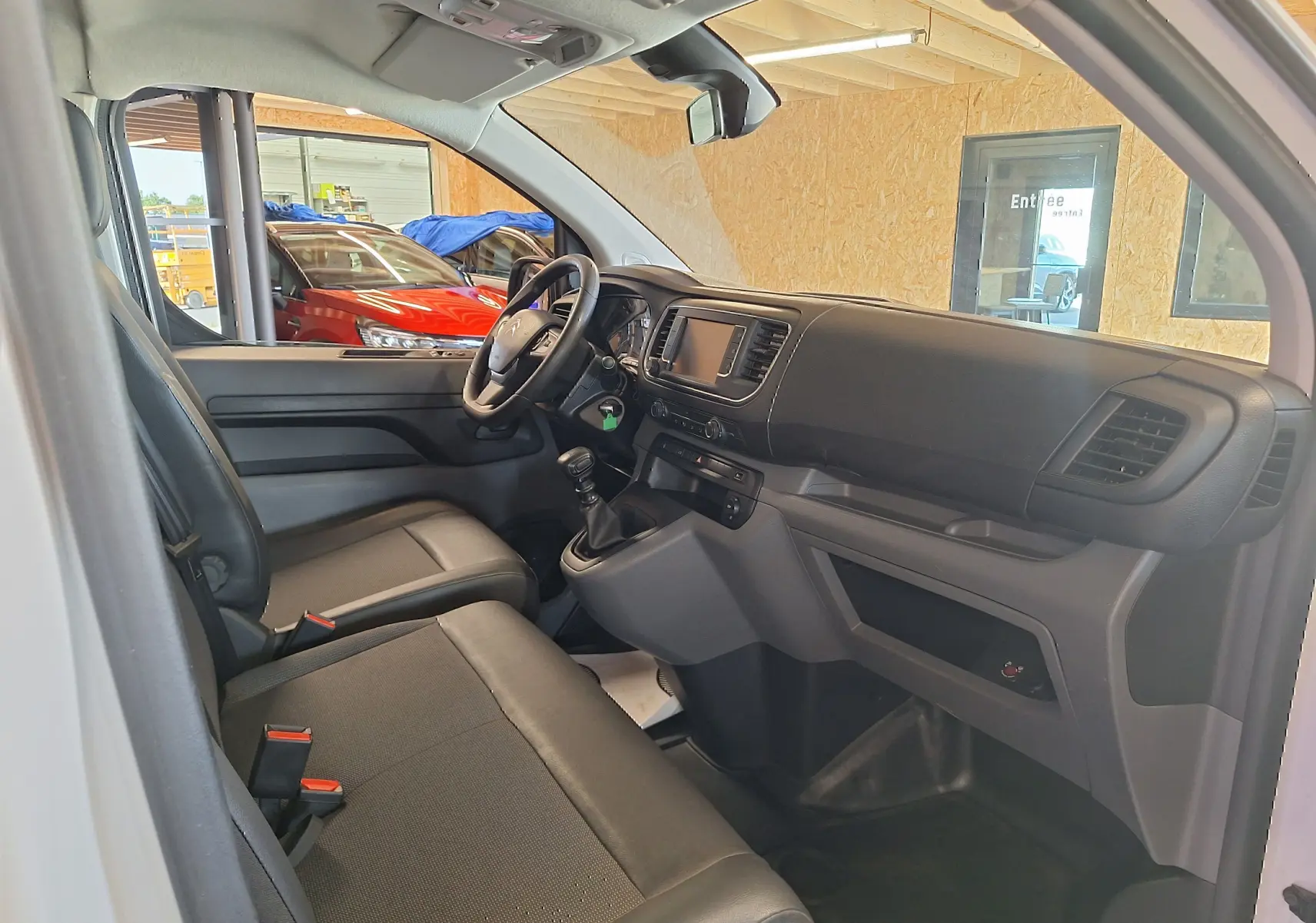 Intérieur du Citroën Jumpy 2.0 BlueHDi 120 Club 2020, vue côté conducteur sur tableau de bord et sièges noirs.