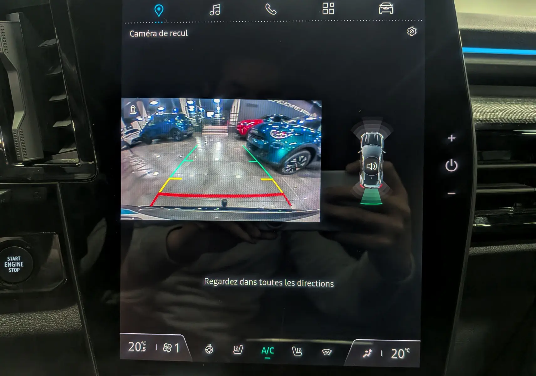 Écran central du Renault Austral 2024 affichant la caméra de recul et l'aide au stationnement en intérieur showroom.