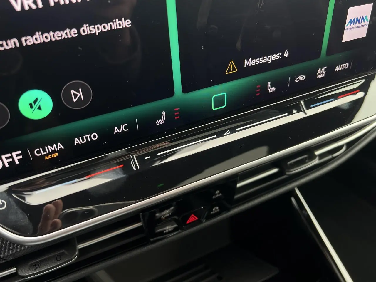 Gros plan sur la console centrale tactile de la Volkswagen Golf VIII noire, avec commandes climatisation et affichage digital.