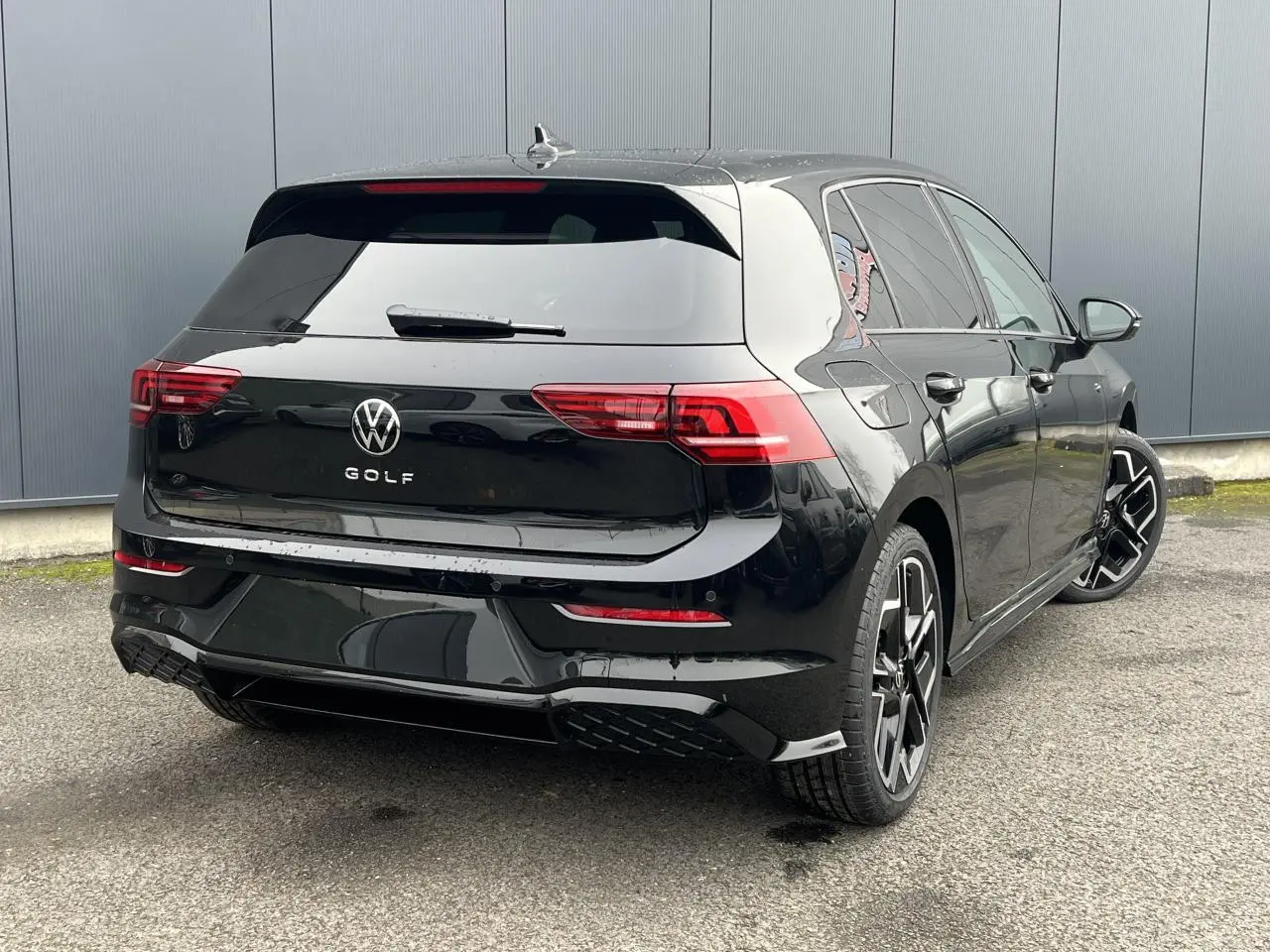 Volkswagen Golf VIII noire vue 3/4 arrière droit avec jantes alliage 18 pouces et toit ouvrant panoramique.