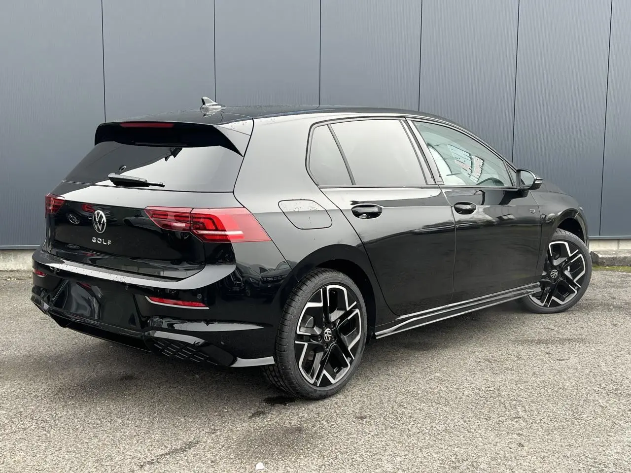 Volkswagen Golf VIII noire vue 3/4 arrière droit avec jantes alliage 18 pouces et toit ouvrant panoramique.