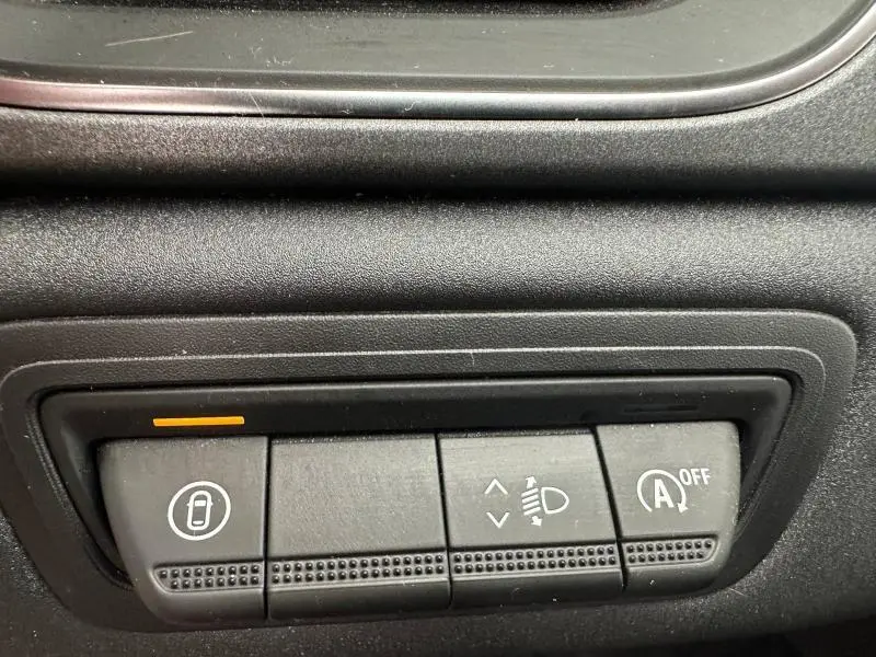 Boutons de commande intérieurs noirs du Renault Captur 2025, avec témoin orange sur le bouton de verrouillage centralisé.