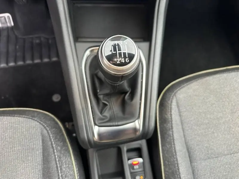 Le levier de vitesse manuel du Renault Captur 2025, entouré de sièges gris et console centrale noire.