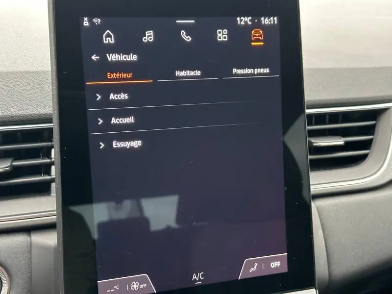 Écran tactile central du Renault Captur 2025 affichant le menu véhicule, intérieur gris avec aérateurs latéraux.