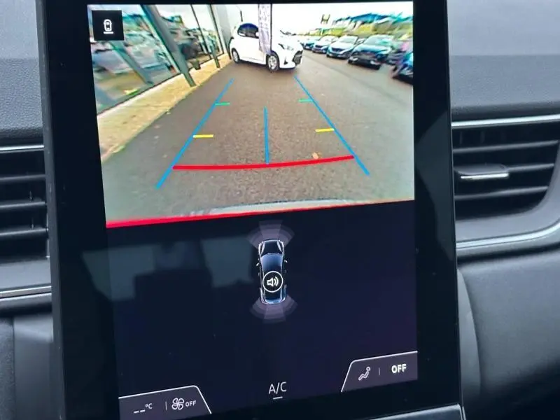 Écran de caméra de recul du Renault Captur 2025 montrant une vue arrière avec lignes de guidage colorées sur route.