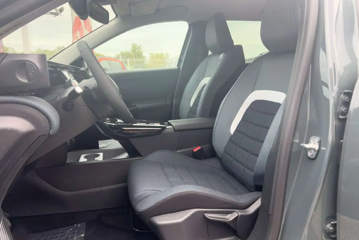 Vue intérieure côté conducteur du Citroën C5 Aircross Hybrid 145 Plus PK Drive 2026, sièges tissu gris avec surpiqûres blanches.