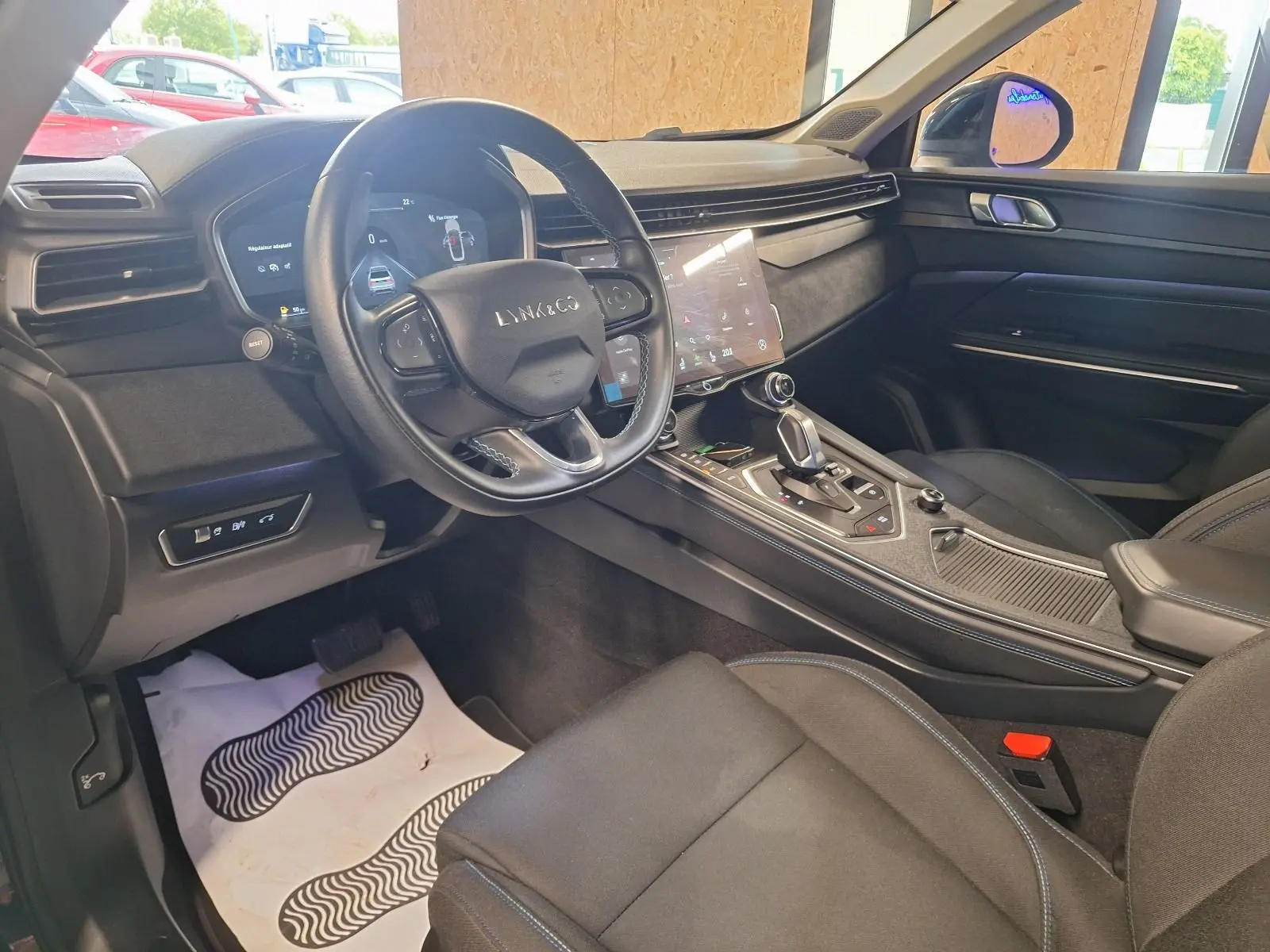 Vue intérieure côté conducteur du Lynk & Co 01 hybride rechargeable noir, avec tableau de bord numérique et console centrale moderne.