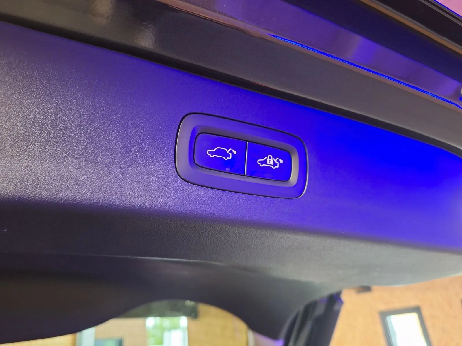 Boutons éclairés en bleu pour ouverture et fermeture automatique du hayon sur un LYNK & CO 01 noir hybride rechargeable.