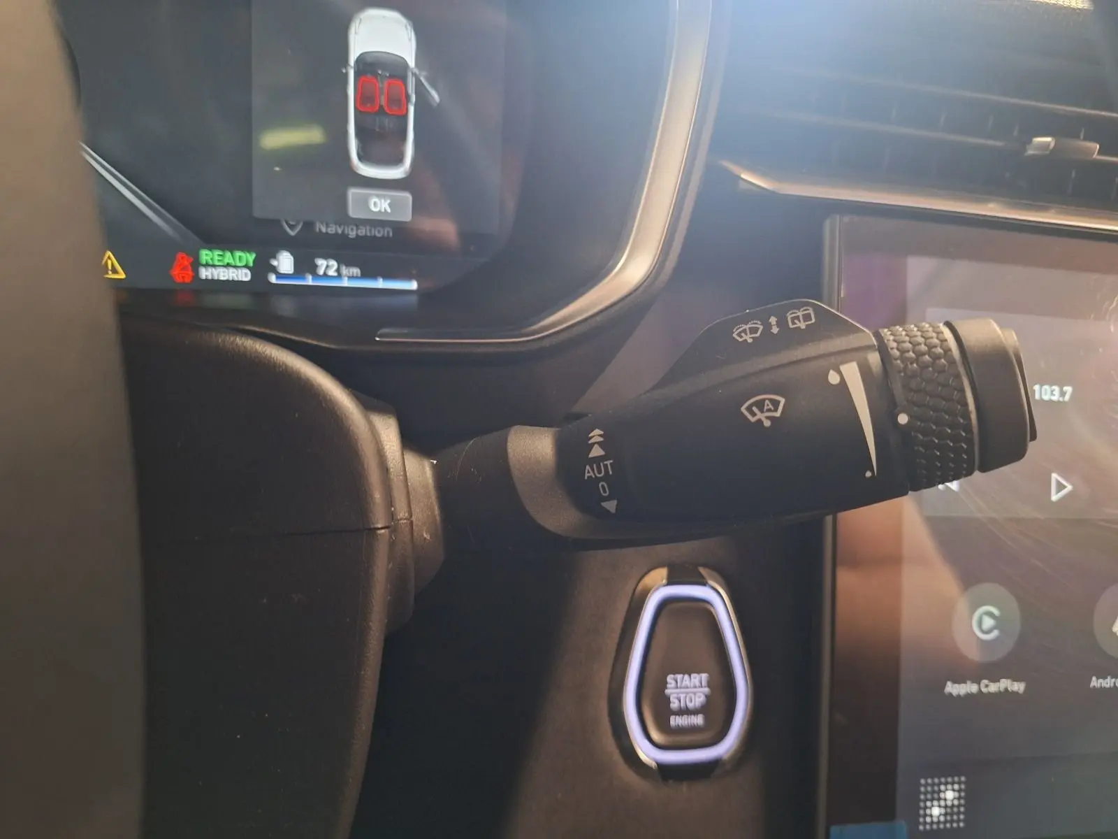 Gros plan sur la manette d'essuie-glace et le bouton start/stop dans l'habitacle du Lynk & Co 01 noir hybride rechargeable.