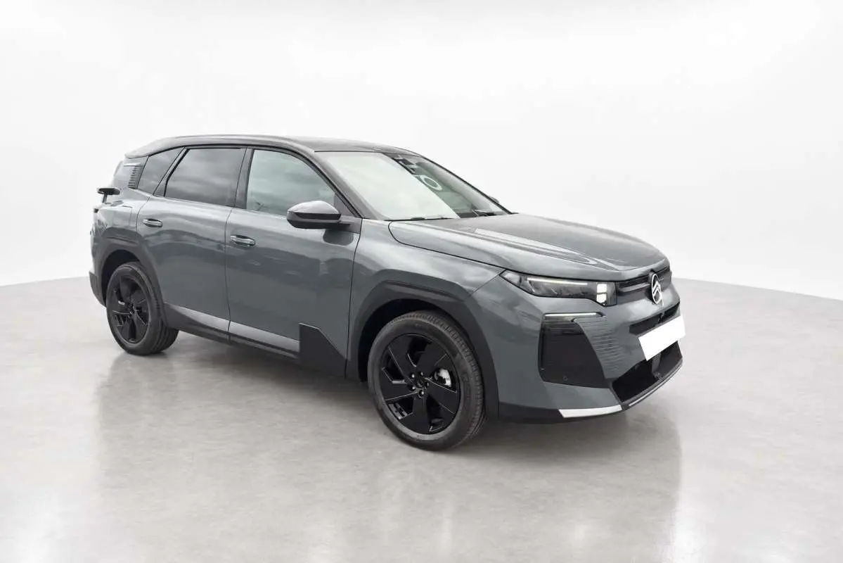 Vue 3/4 avant droit du Citroën C5 Aircross hybride 2026 gris métallisé avec jantes noires et vitres surteintées.
