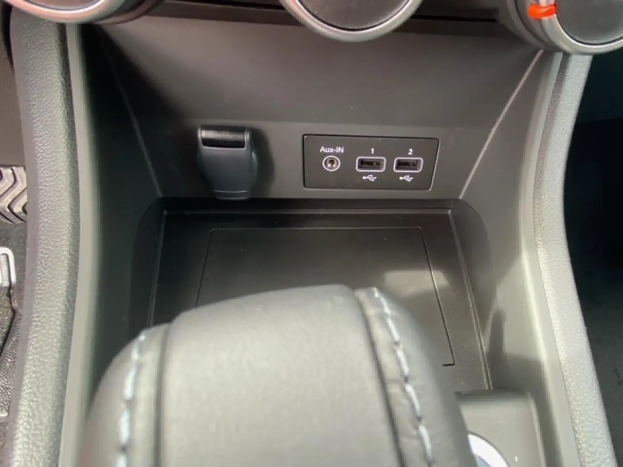 Vue rapprochée de la console centrale du Renault Captur bleu, montrant les ports USB et prise Aux-IN.