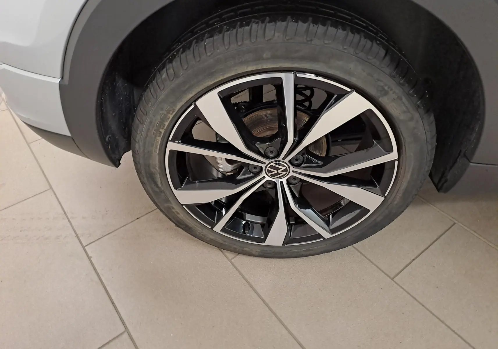 Gros plan sur la roue avant droite du Volkswagen T-Cross 2025 R-Line Edition en Reflet d'argent, jante alliage bicolore.