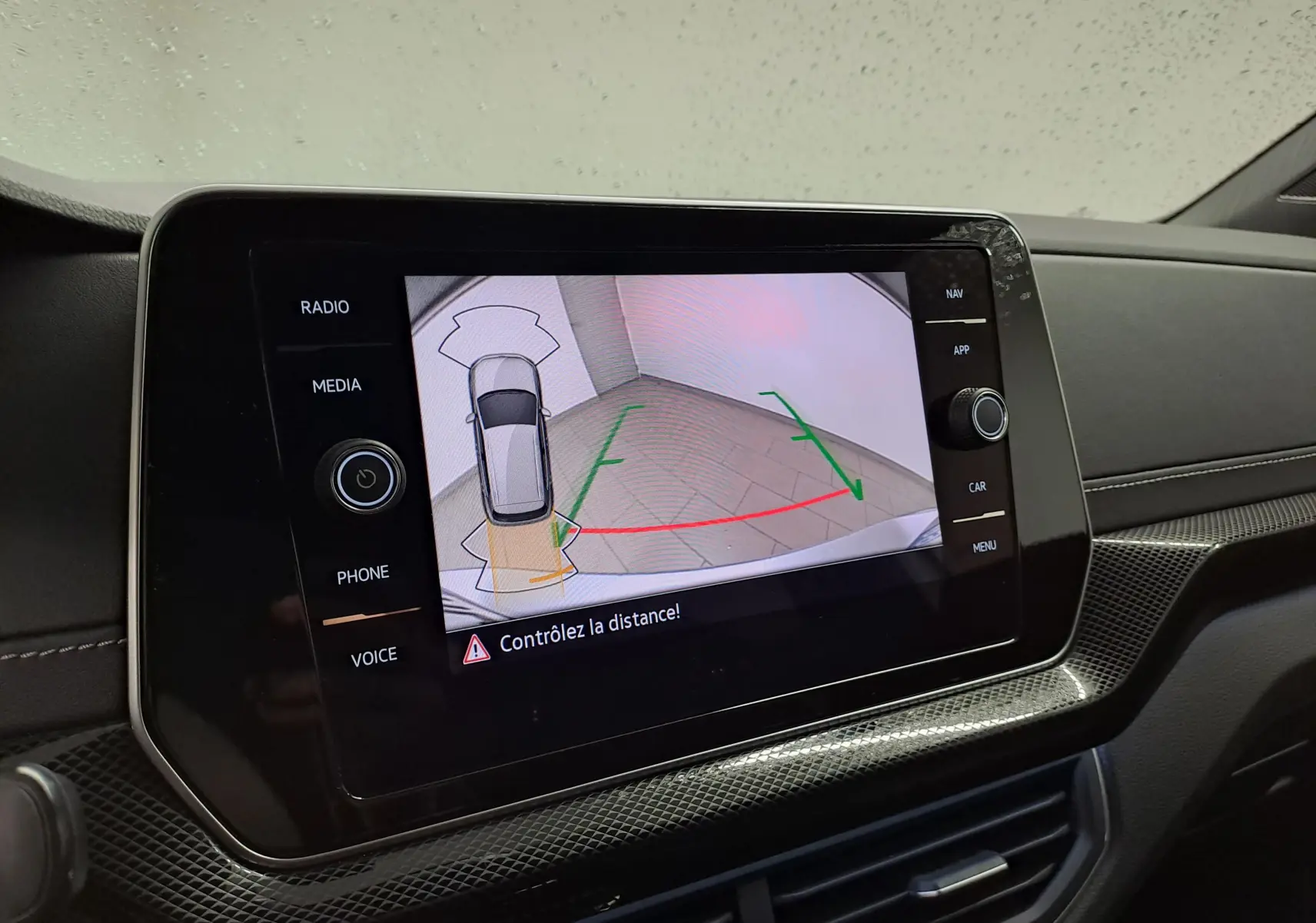 Écran tactile intérieur du Volkswagen T-Cross 2025 affichant la caméra de recul avec guidage de trajectoire.