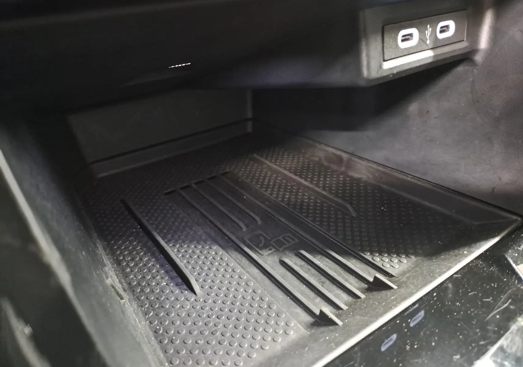 Gros plan sur le chargeur sans fil noir et les ports USB dans l'habitacle du Volkswagen T-Cross 2025 R-Line Edition.