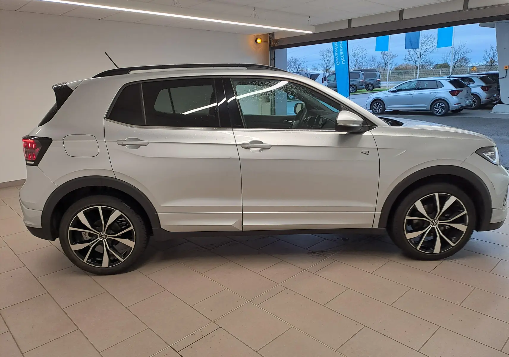 Vue latérale droite du Volkswagen T-Cross 2025 R-Line Edition en Reflet d'argent, avec jantes alliage noires et détails noirs contrastants.