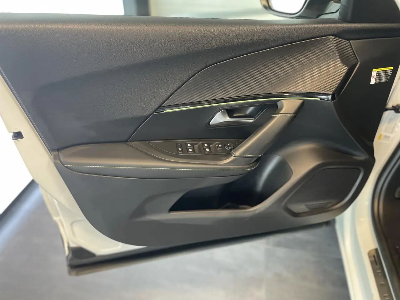 Porte avant gauche ouverte de Peugeot 2008 GT Line 2019, intérieur noir avec surpiqûres et insert carbone.