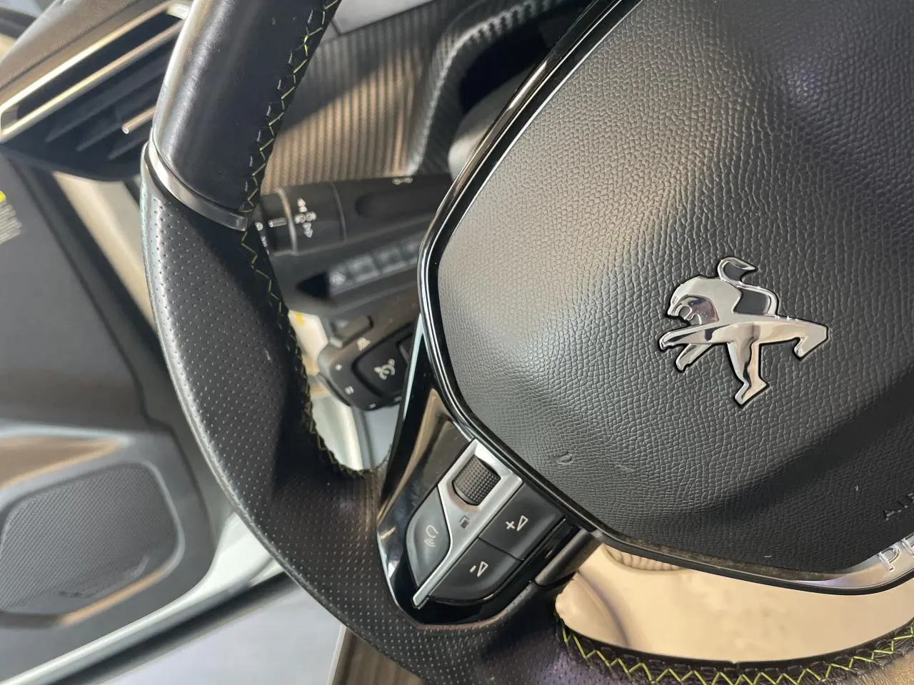 Gros plan sur le volant cuir noir avec surpiqûres vertes du Peugeot 2008 GT Line 2019, intérieur visible.