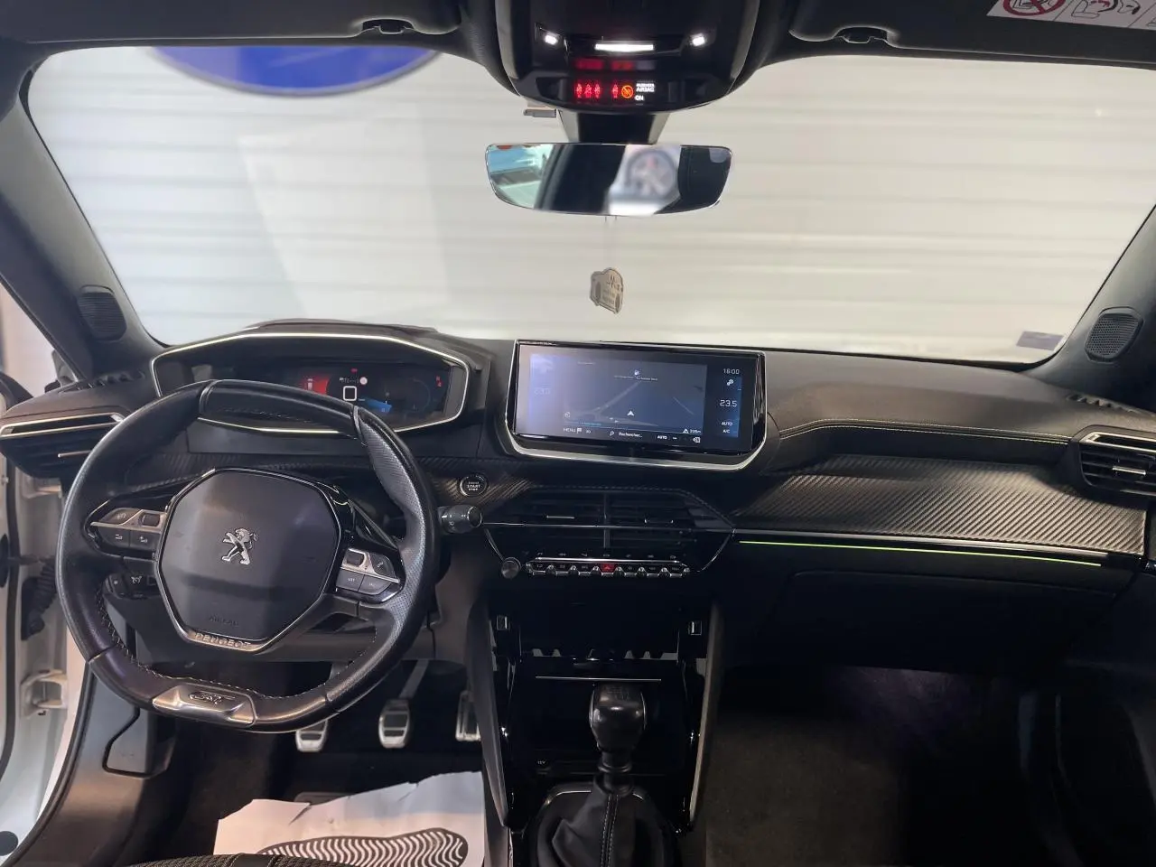 Intérieur avant du Peugeot 2008 noir, tableau de bord avec écran tactile et volant compact cuir noir.