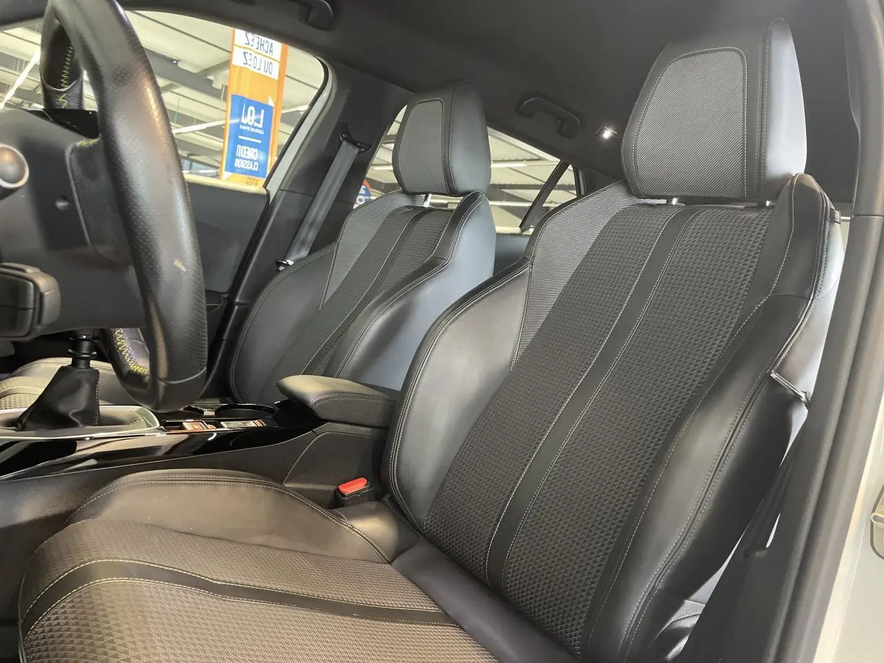 Intérieur Peugeot 2008 GT Line 2019, vue rapprochée des sièges avant en tissu et cuir noir avec surpiqûres contrastées.