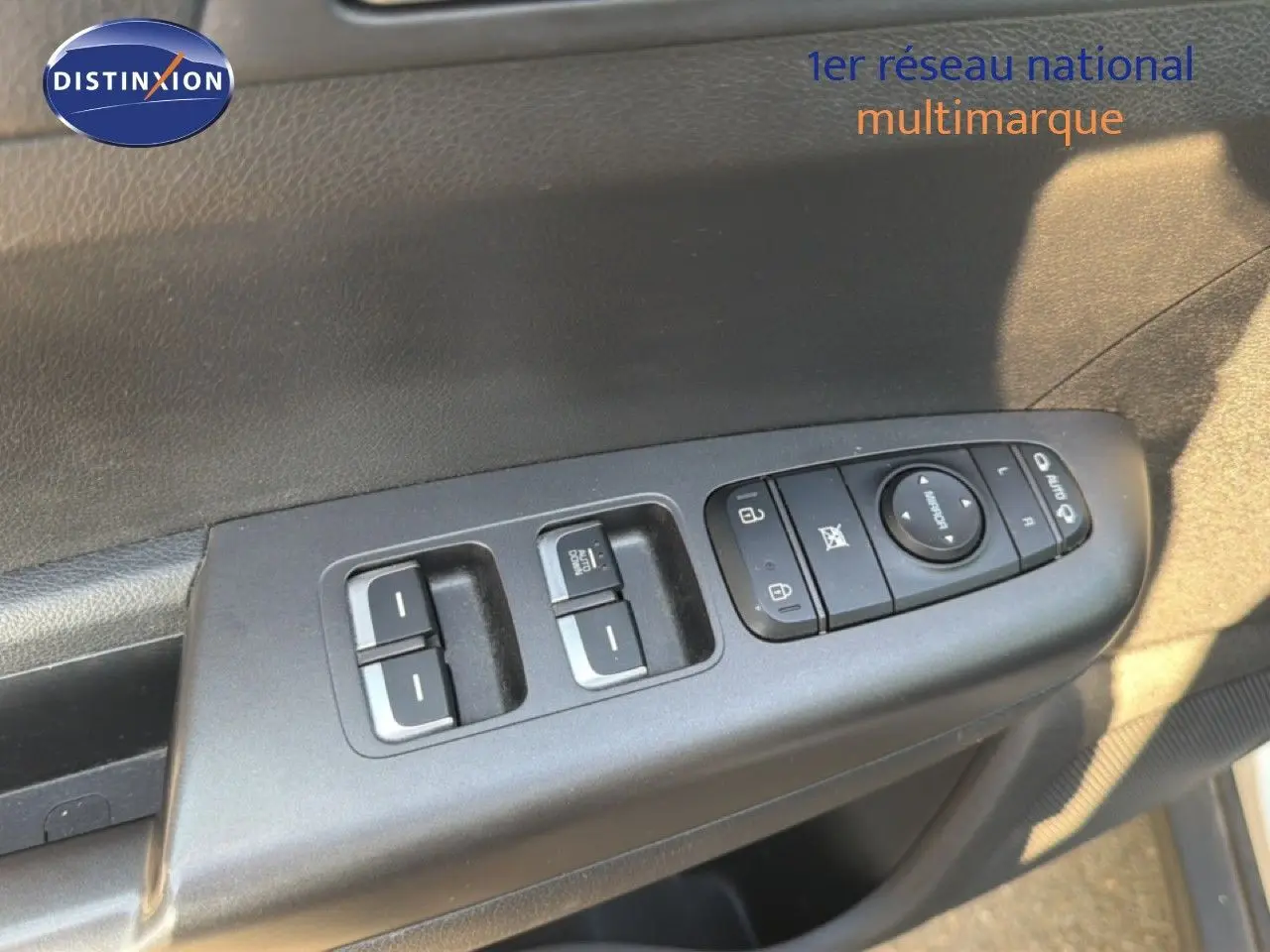 Gros plan sur les commandes de lève-vitres et rétroviseurs côté conducteur du KIA Sportage blanc nacré 2021.