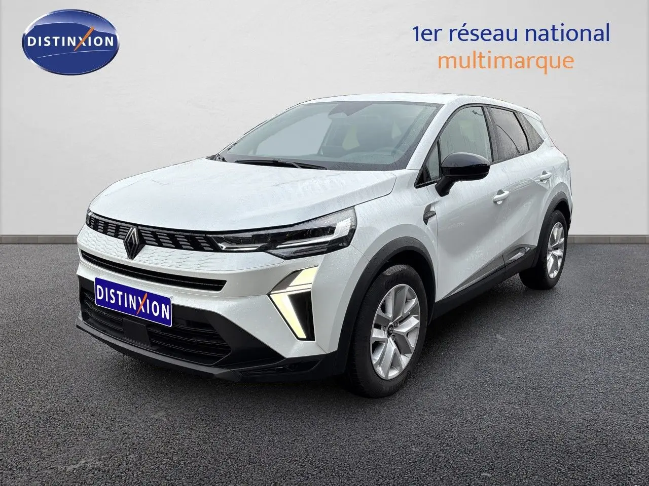Renault Symbioz blanc nacré métal en 3/4 avant droit, avec calandre noire et feux LED distinctifs allumés.