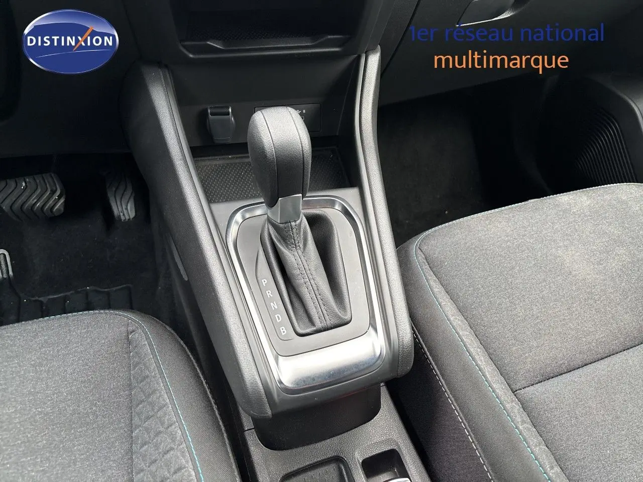 Gros plan sur la console centrale et levier de vitesse automatique d’un Renault Symbioz blanc nacré, sièges tissu gris.