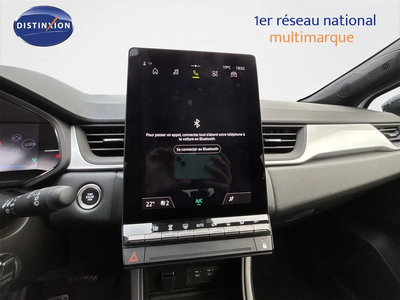 Vue intérieure centrée sur l'écran tactile vertical du tableau de bord de la Renault Symbioz blanc nacré, avec commandes climatisation visibles.