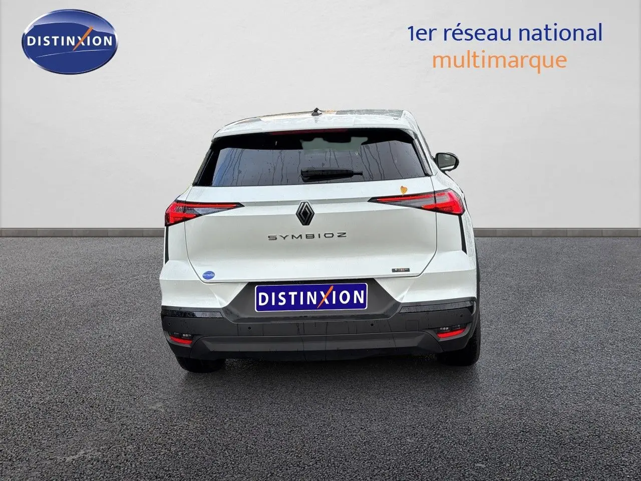 Vue arrière d'une Renault SYMBIOZ blanc nacré métal, avec feux arrière fins et logo central visible.
