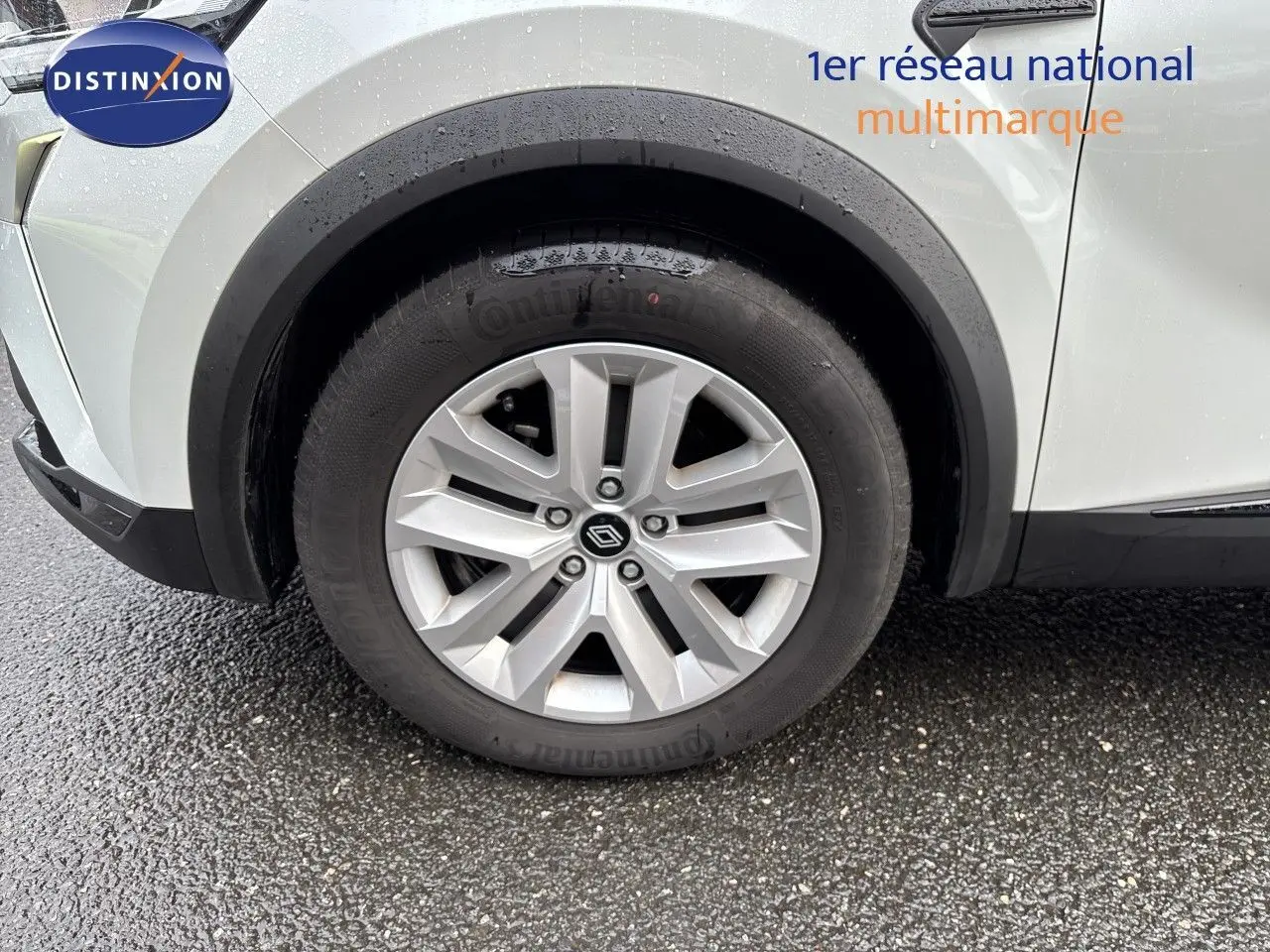 Gros plan sur la roue avant gauche d’un Renault Symbioz blanc nacré, avec jante alliage et pneu Continental.