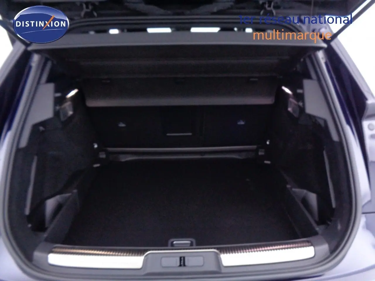 Coffre ouvert du DS7 Crossback bleu encre métal, vue arrière montrant l'espace de chargement spacieux et bien fini.