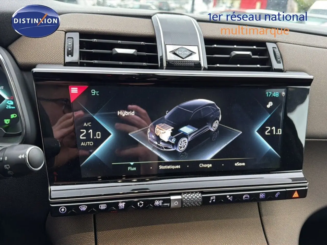 Écran tactile central du DS7 Crossback bleu encre métal, affichant les informations hybrides et climatisation à 21°C.