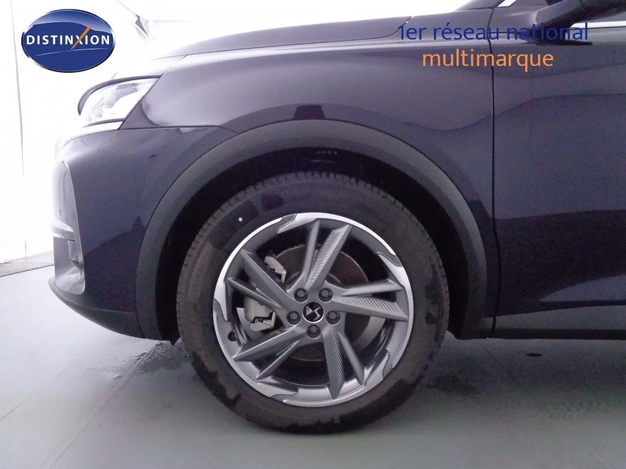 Vue 3/4 avant droit d'un DS7 Crossback hybride rechargeable bleu encre métal avec feux LED et jantes alliage.