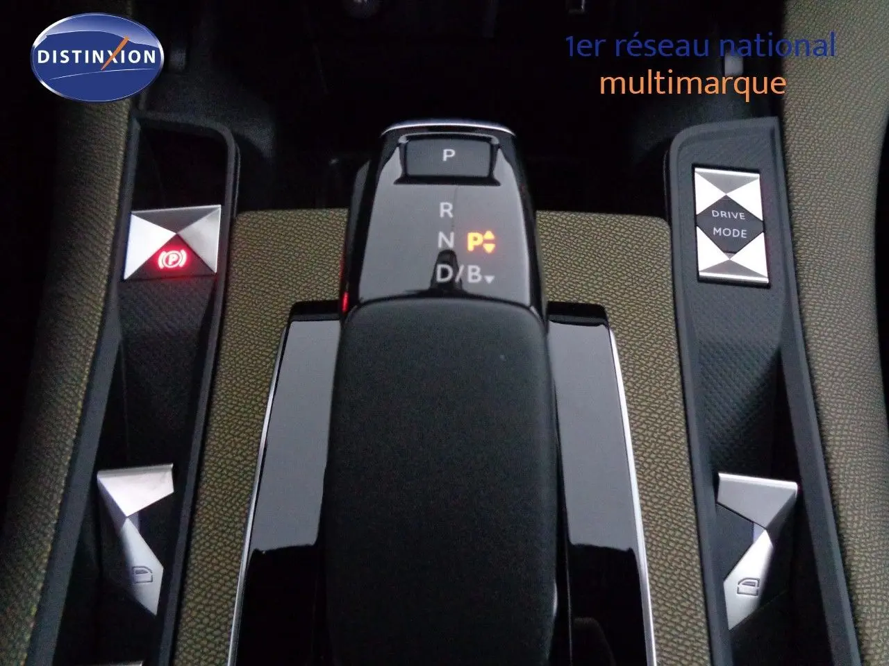 Gros plan sur la console centrale du DS7 Crossback bleu encre, montrant le levier de vitesse automatique et les boutons de mode de conduite.