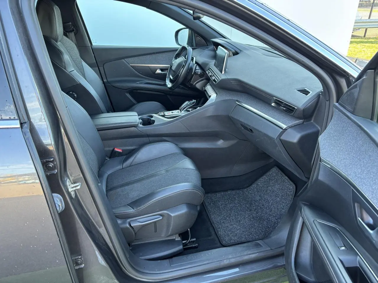 Intérieur du Peugeot 3008 gris métal 2020, vue côté passager avant, sièges cuir et tableau de bord moderne.