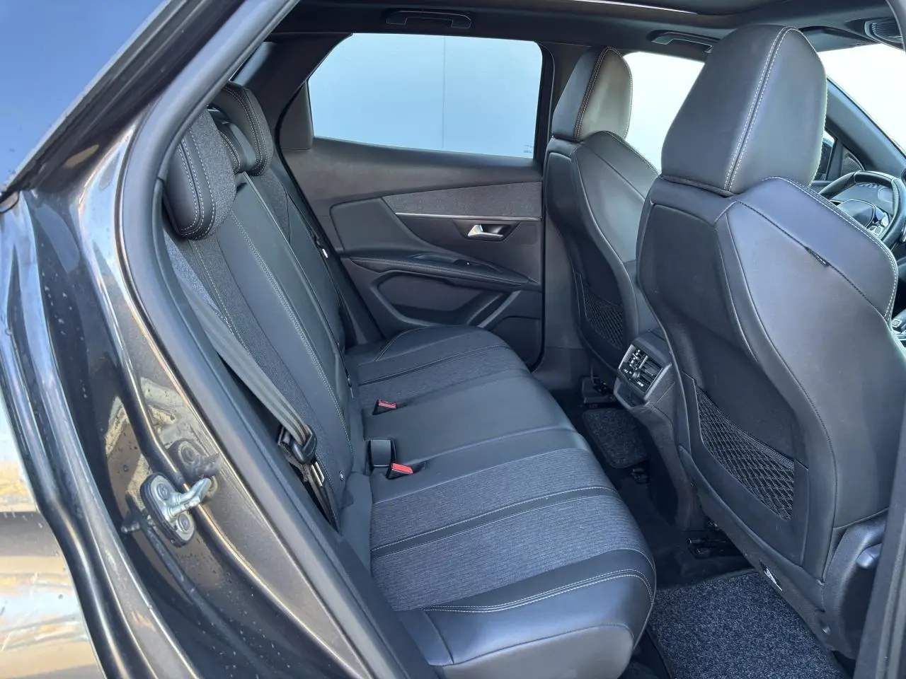 Vue intérieure côté gauche sur les sièges arrière en tissu et cuir du Peugeot 3008 gris métal, version GT Line 2020.