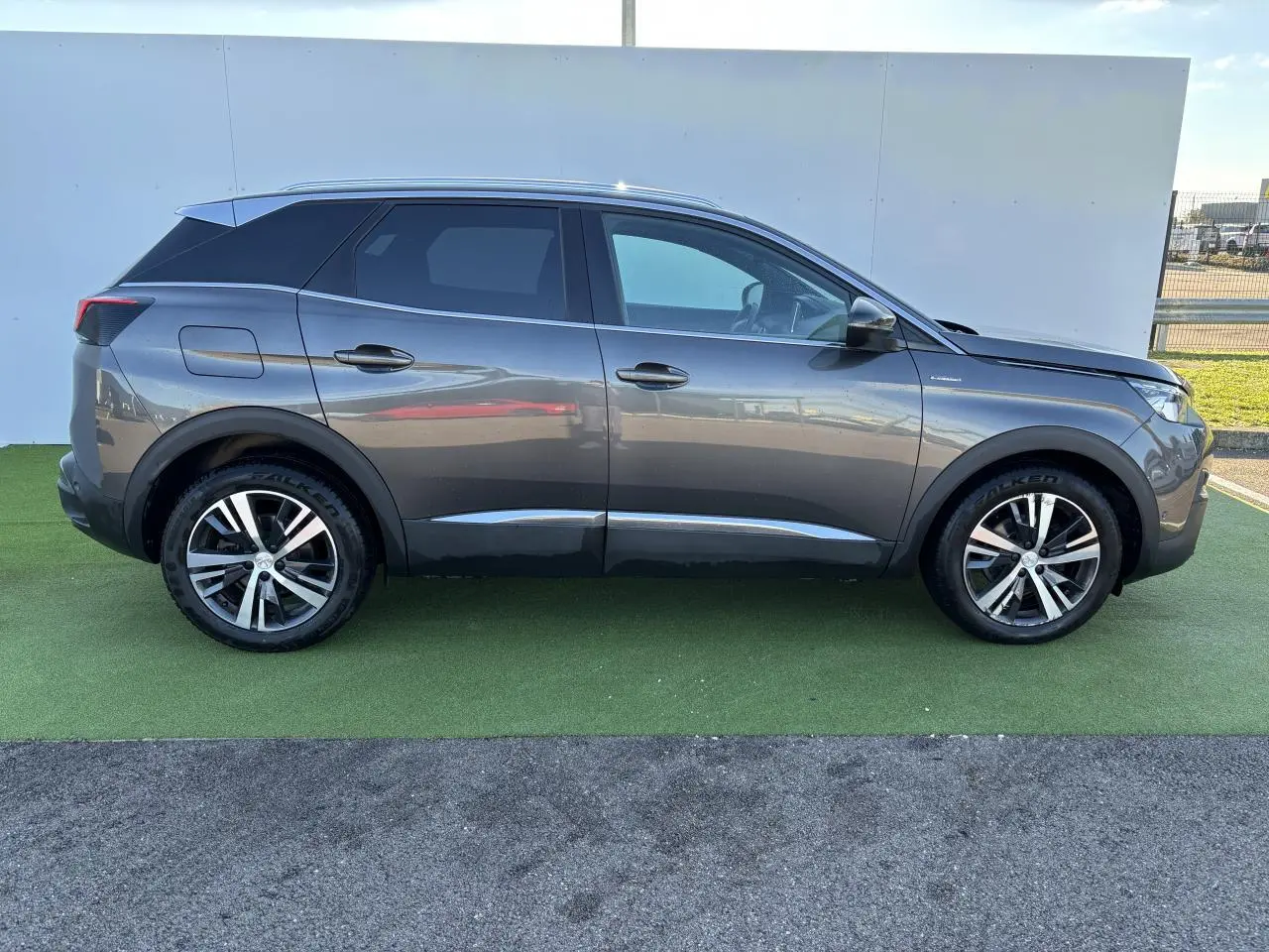 Profil côté droit du Peugeot 3008 gris métal de 2020, version GT Line avec jantes alliage et toit noir contrasté.