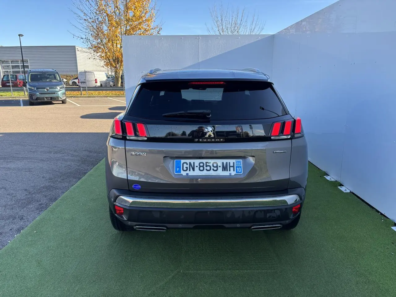 Vue arrière d'un Peugeot 3008 gris métal de 2020, avec feux arrière à trois griffes rouges caractéristiques.