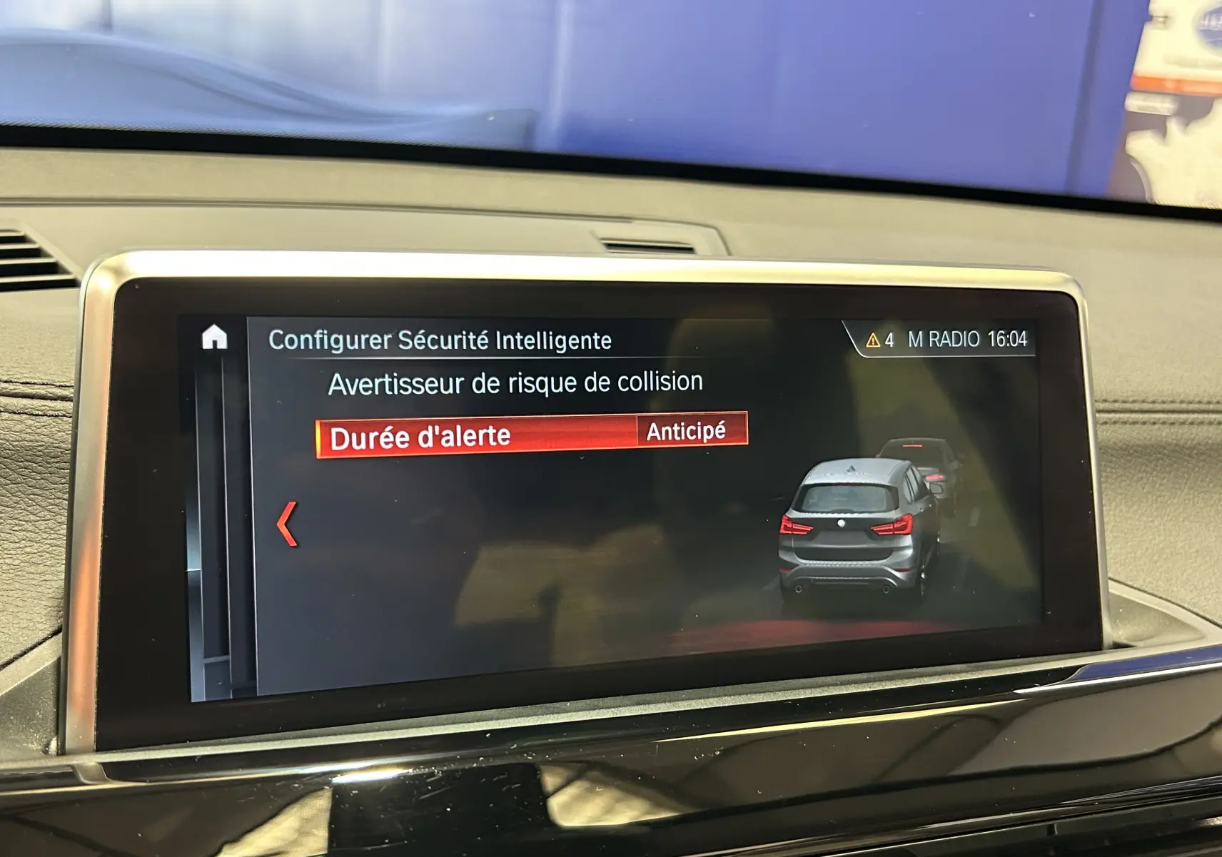 Écran central de BMW X1 2019 affichant la configuration de l'avertisseur de risque de collision en mode anticipé.