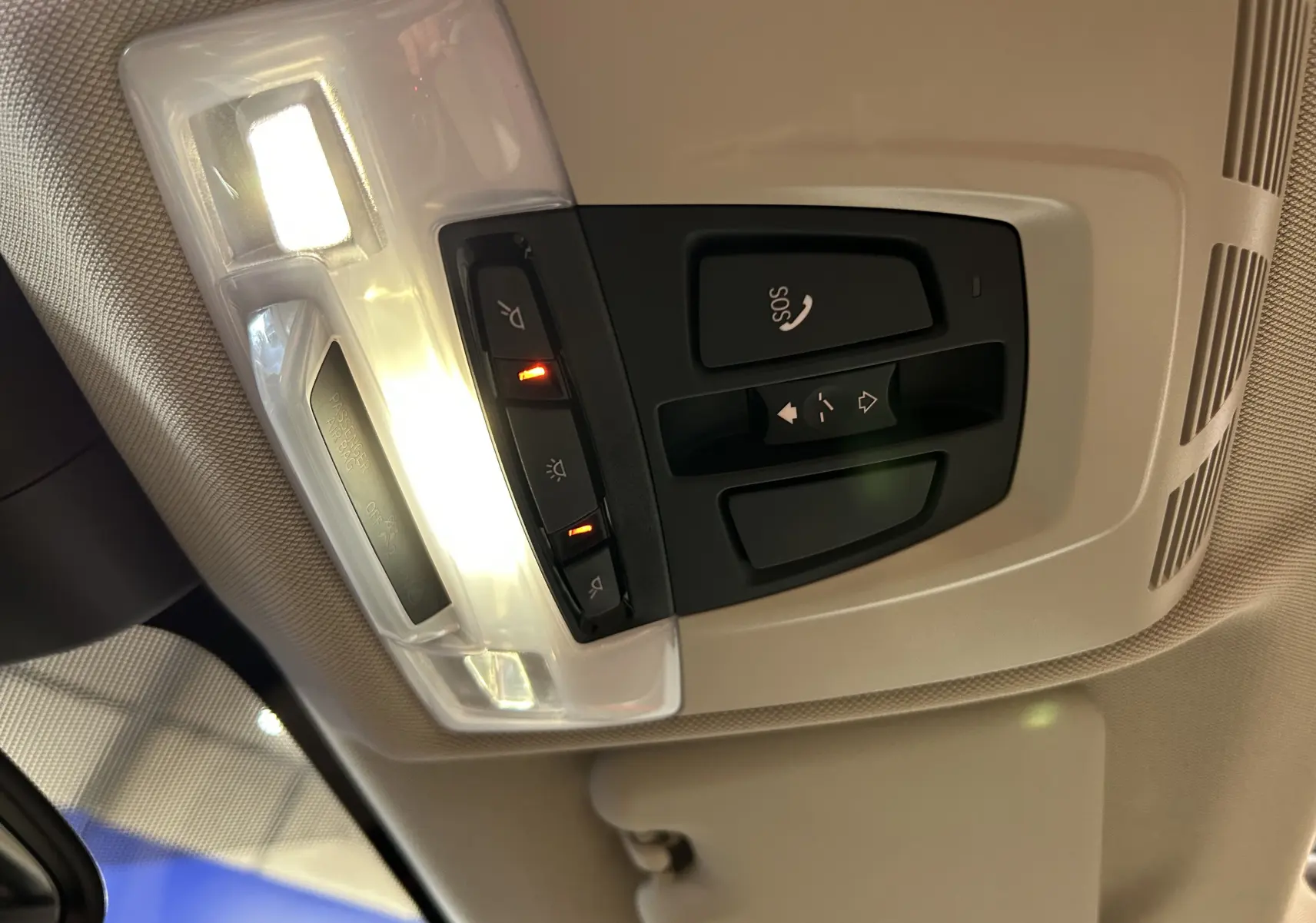 Vue intérieure du plafonnier avec commandes d’éclairage et bouton SOS dans un BMW X1 noir de 2019.