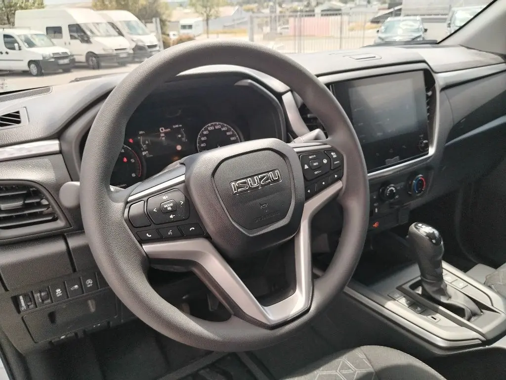Vue intérieure centrée sur le volant multifonction d'un Isuzu D-MAX 2026 avec tableau de bord et écran tactile.