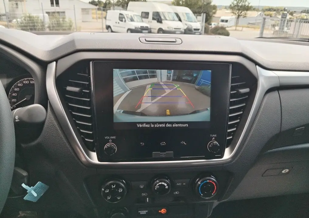 Vue intérieure du tableau de bord de l'Isuzu D-MAX 2026 avec écran de caméra de recul affiché.